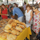 Unos clientes del Mercado frente a un puesto de pan ecológico.-J. M. LOSTAU