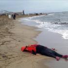 Un miembro de los equipos de rescate contempla el cuerpo de un inmigrante sobre la playa en Ayvalink (Turquía).-AP