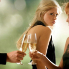 Una mujer siente celos al ver a una pareja brindar.-123RF