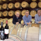 De izda. a dcha.: Martín Padín, Santos Calvo y Alfonso Garcés, en la nave de barricas de la bodega y dos de sus vinos más representativos.-ARGICOMUNICACIÓN
