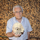 El sacerdote José Luis Velasco, con una calavera del osario de la iglesia de Wamba, pequeña población vallisoletana situada en los Montes Torozos.-AGRICOMUNICACIÓN