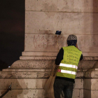 Anti-government protester scrawls graffiti that reads  Macron resign   on the wall of the Arc de Triumph in central Paris.-Zakaria ABDELKAFI   AFP