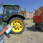 Imagen de un hombre junto a un tractor.-J.M.LOSTAU