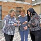 Belén, Plácida y Teresa cambian impresiones sobre la falta de cobertura con un teléfono móvil ayer, en la Plaza Mayor de San Martín de Valvení.-S. G. C.