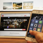 Un usuario consulta sus aplicaciones de redes sociales, en el móvil y en la tablet.-JULIO CARBÓ