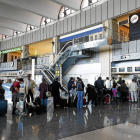 Varios viajeros esperan cola para facturar sus equipajes en el aeropuerto de Barajas-El Mundo