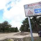 Un ciclista circula por la carretera, donde luce un cartel de precaución.-ICAL