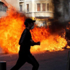 Unos jóvenes queman contenedores de basura en Marsella durante una manifestación contra los planes fiscales del Gobierno francés.-JEAN-PAUL PELISSIER (REUTERS)