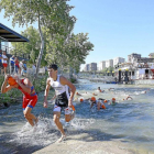 Los participantes de la competición salen del río Pisuerga para comenzar la prueba de bicicleta.-Ical
