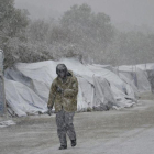 Varios refugiados caminan bajo la nieve en el campamento de refugiados de Moria en la isla de Lesbos, Grecia.-EFE / STRATIS BALASKAS