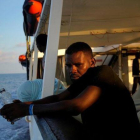 Un migrante en la cubierta del Open Arms.-JUAN MEDINA (REUTERS)