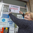 Carmen Lino pega el cartel del premio en su copistería del barrio de Pajarillos.-Miguel Ángel Santos