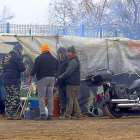 Varios moteros se preparan para comer en la zona de acampada, junto a sus tiendas.-ICAL