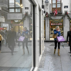 Dos personas pasean con bolsas de compras por la calle Santiago.-MIGUEL ÁNGEL SANTOS
