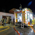 Los bomberos, trabajando para apagar el fuego del garaje.-J. M. LOSTAU