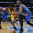 Andre Roberson y Serge Ibaka corren por el balón, en el choque entre los Thunder y los Nuggets en Denver.-Foto:   AP / DAVID ZALUBOWSKI