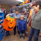 La dependienta de un bazar muestra un disfraz de calabaza  a un niño y su abuela.-J.M. LOSTAU