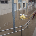 Una calle inundada en Miranda con sacos para frenar en agua en los negocios.-ECB