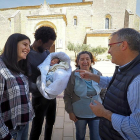 Sara Pérez y Andrés Rodríguez muestran a su hijo Dylan al alcalde de Benafarces, Luis Chico, en presencia de la abuela materna, Rosario Alonso, frente a la iglesia de la localidad.-MIGUEL ÁNGEL SANTOS