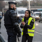 Una manifestante con el chaleco amarillo, símbolo de la protesta, habla con un policía, esta mañana en los alrededores de París.-EPA