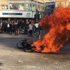 Manifestantes iranís junto a una motocicleta quemada en Isfahan (Irán).-AFP