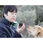 Una truficultora observa un muy buen ejemplar de trufa negra ante la atenta mirada del perro utilizado para detectar el aroma del hongo y por tanto su ubicación.-LUIS ÁNGEL TEJEDOR