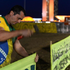 Un partidario de Rousseff clava un cartel en las afueras del senado brasileño.-ANDRESSA ANHOLETE / AP / AFP