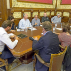 Puente y Saravia, de espaldas, escuchan la intervención de Parellada en la reunión.-Miguel Ángel Santos
