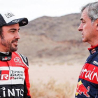 Fernando Alonso y Carlos Sainz conversan tras finalizar la etapa de hoy en el Dakar.-DPPI / FREDERIC LE FLOCH