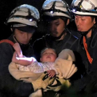 Un bebé de ocho meses rescatado por los trabajadores de emergencias el viernes en Japón.-REUTERS / DAISUKE WADA