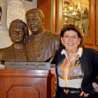Marisa Duque, junto al busto de bronce de sus padres, situado en el interior del mesón segoviano.-ARGICOMUNICACIÓN