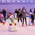 Varios niños y jóvenes patinan y juegan en la pista de hielo.-J.M. LOSTAU
