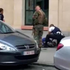 Dos policías y un militar, junto al hombre abatido ayer en Bruselas.-AFP
