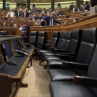 La bancada azul del Gobierno permanece vacía mientras la oposición pide explicaciones al también ausente Luis de Guindos, en el pleno del Congreso.-JOSE LUIS ROCA