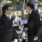 Carles Puigdemont y Mariano Rajoy se saludan este viernes, en Barcelona, antes de la inauguración del Salón de Automóvil de Barcelona.-JOAN CORTADELLAS
