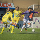 Anuar saca el balón ante dos jugadores de la Arandina.-MIGUEL ÁNGEL SANTOS