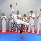 Flavio Oliveira realiza un acrobático movimiento ante la mirada de sus alumnos, que le acompañan con la música.-J. M. LOSTAU