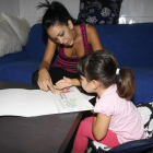 Una madre ayuda a su hija con los deberes encargados en el colegio.-J. MARTI