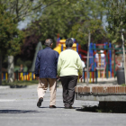 Dos ancianos pasean por el parque.