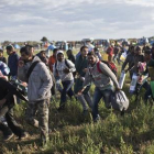 Refugiados a su paso por tierras húngaras, en el 2015.-MARKO DROBNJAKOVIC (AP)