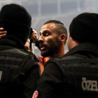 Yasin Oztekin se abraza a dos policías en el estadio del Galatasaray.-AFP