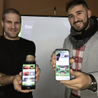 Marcelino García y Daniel Falagán enseñan la aplicación en la que las empresas publicitan sus ofertas.-EL MUNDO