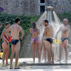Bañistas en la playa de Las Moreras protegiéndose del calor en la ducha.-PABLO REQUEJO / PHOTOGENIC