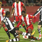 Olunga es frenado por un defensa del Levante durante el partido de Copa del jueves.-JOAN CASTRO / ICONNA