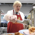 El primer ministro británico, Boris Johnson, sirve el sábado comida de Navidad a las tropas británicas estacionadas en Estonia.-AP / STEFAN ROUSSEAU