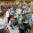 Varias personas realizan sus compras en un supermercado.-J.M. LOSTAU