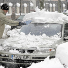 Un hombre retira la nieve de su coche en Burgos.-ICAL