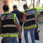 Policías de Valladolid salen del registro del domicilio  del británico , con dos portátiles y una caja de documentos.-E. M.