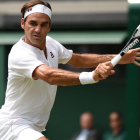Federer devuelve un revés, en su partido con Mannarino en Wimbledon.-AFP / OLI SCARFF
