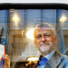 Jeremy Corbyn fotografiado en el interior de un vagón de tren sujetando dos billetes.-REX SHUTTERSTOCK / TOLGA AKMEN